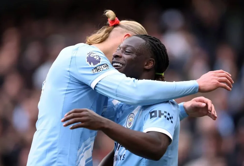 Jeremy Doku celebrates scoring with Erling Haaland